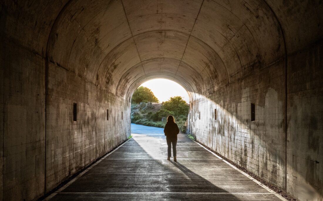 Hipnoza regresyjna – osoba stojąca w tunelu z widocznym światłem na końcu jako metafora pracy z przeszłością